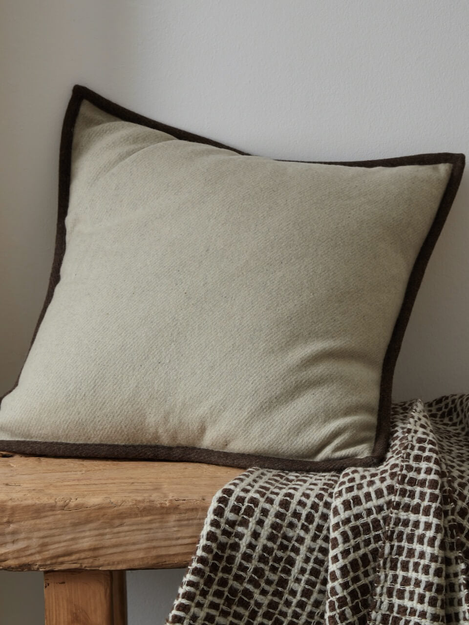 Housse de coussin en laine crème avec bordure marron