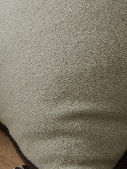 Housse de coussin en laine crème avec bordure marron